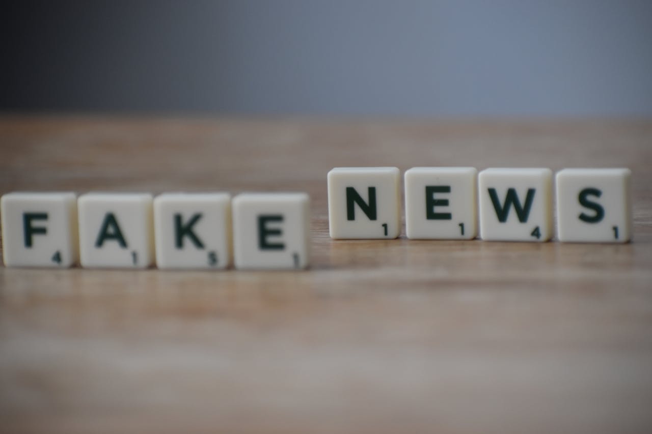 Scrabble tiles spelling Fake News on a wooden surface highlighting misinformation.