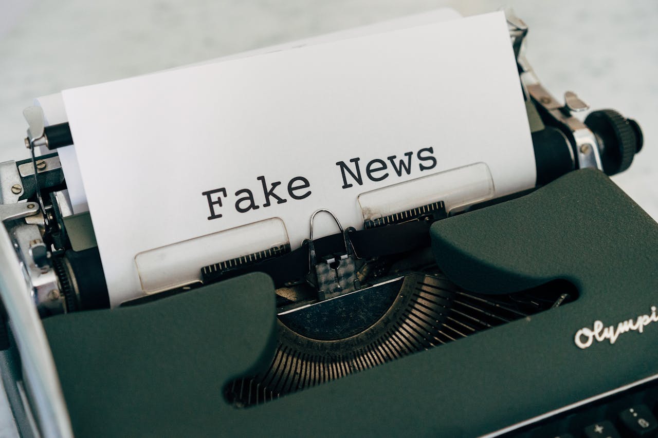 Close-up of vintage typewriter printing Fake News, depicting false information concepts.