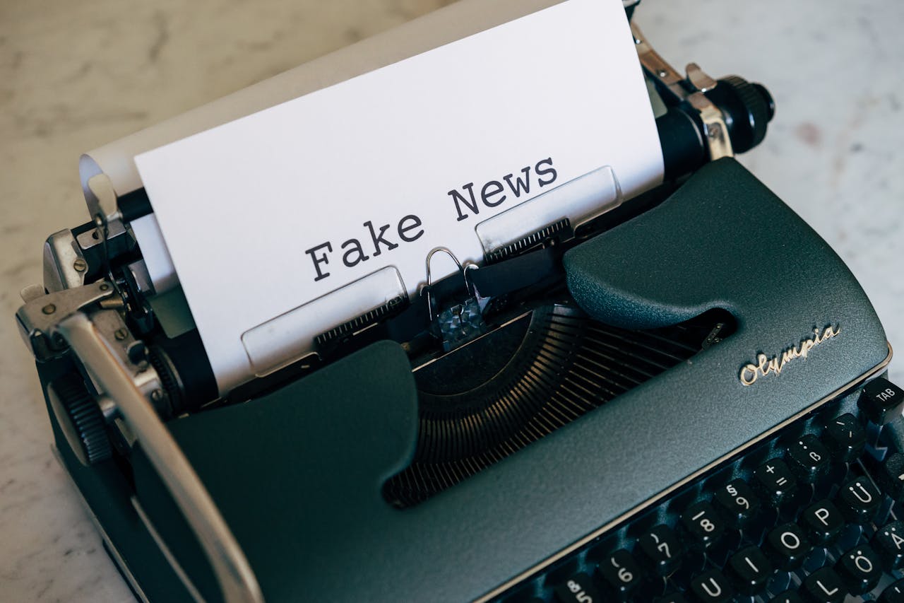 Close-up of a vintage typewriter displaying the words Fake News on paper.